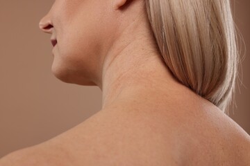 Back view of woman with healthy skin on beige background, closeup