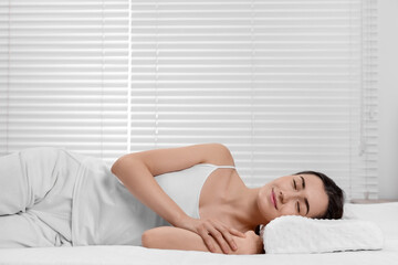 Fototapeta premium Woman sleeping on orthopedic pillow at home, space for text