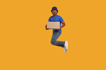 Happy courier with parcel jumping on orange background