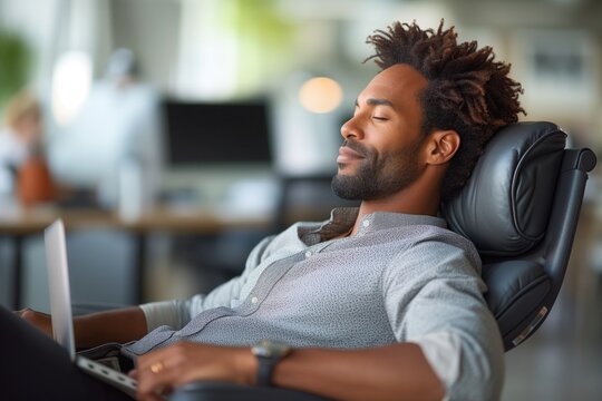 Posture Problems: Slouched in their chairs, employees suffer from poor posture as they spend hours hunched over their laptops, resulting in backaches and neck pain from the prolonged sitting 