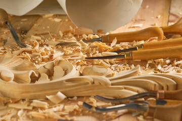 Hands of craftsman carve with gouge in hands on workbench in carpentry close-up. Wood Carving...