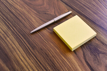 Bolígrafo y libreta de notas amarilla. Accesorios de oficina, espacio para texto al lado izquierdo. - obrazy, fototapety, plakaty