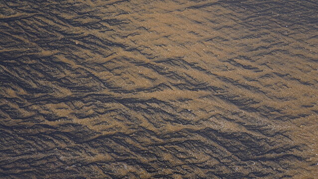 Beautiful sand pattern formed by yellow and black grains in muttom beach