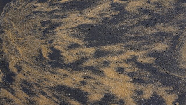 Beautiful sand pattern formed by yellow and black grains in muttom beach