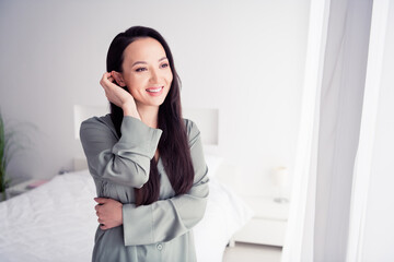 Photo portrait of lovely young lady tuck hair behind ear wear trendy gray sleepwear isolated on white bedroom indoor interior