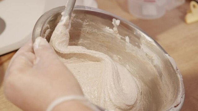 Pastry Chef mixing with hands dough for macaroons.