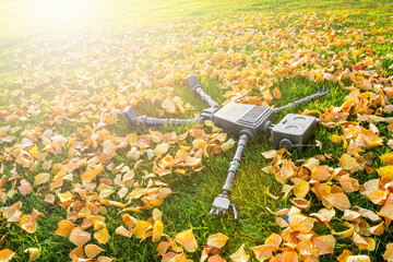 Happy humanoid robot lies on the grass in fallen leaves. Concept of technology development in the...