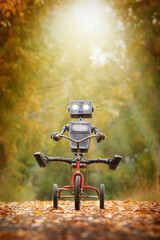 Happy humanoid robot rides a bicycle along the autumn alley. Robotic object experiences feelings and emotions. Concept of technology development in the form of artificial intelligence. - 738125638