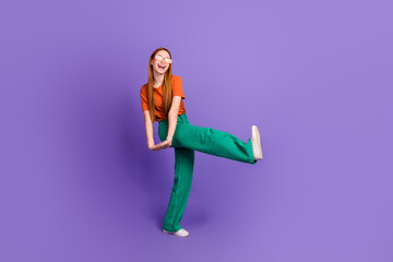 Full length photo of optimistic glad shiny girl wear trendy outfit dance raise leg special sale offer isolated on purple color background