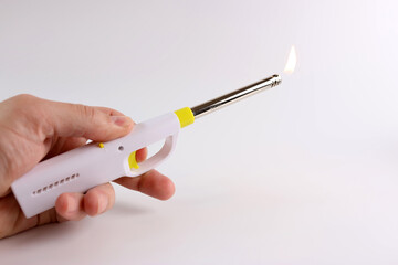 Lighter with lit fire on a white background.