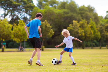Kids play football. Child at soccer field.