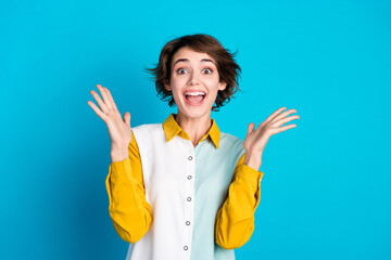 Photo of funky excited woman wear shirt open mouth rising arms empty space isolated blue color...