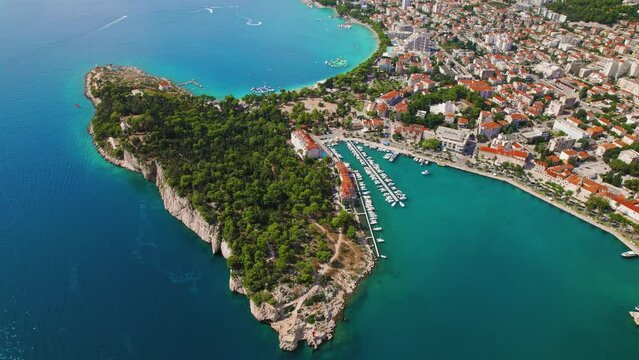 Makarska Riviera breathtaking coastal view. Aerial view of town revealing a stunning lush greenery, urban architecture. Adriatic Sea.