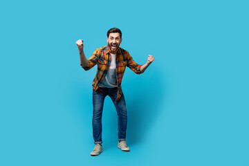Fototapeta na wymiar Full size photo of handsome young male fists scream support sport team dressed stylish checkered outfit isolated on blue color background