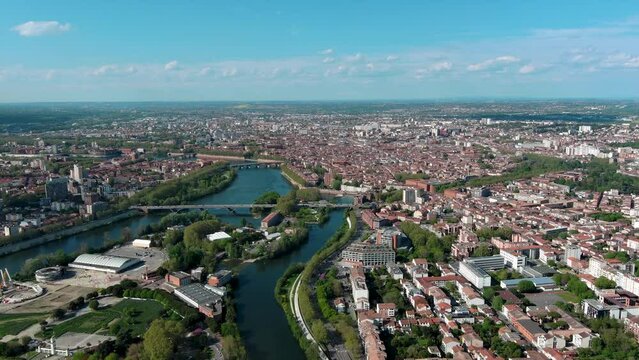 Toulouse aerial panoramic view. It's the capital of Haute Garonne department and Occitanie region in France. Terra-cotta bricks used in many of its buildings ft Garonne River and urban city skyline 4K