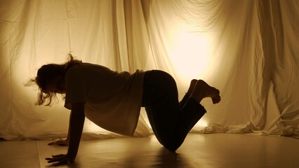 Silhouette contemporary experimental choreography concept. Female dancer performing in the studio....