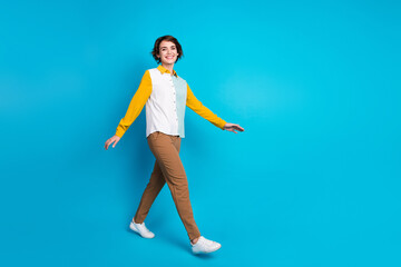 Full body length photo of positive secretary or assistant in office young woman in formalwear steps isolated on blue color background
