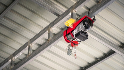 Electric Hoist hangs on a steel frame ceiling in an industrial production workshop.