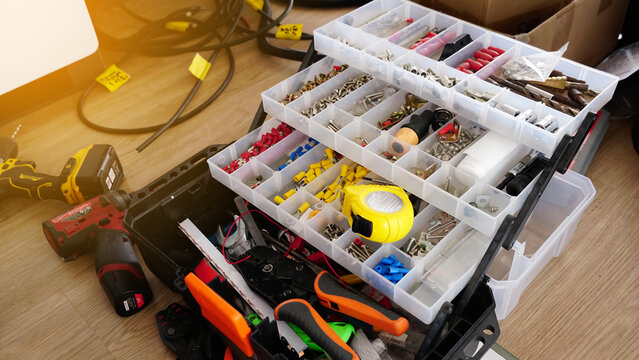Materials parts in electrical installation in portable plastic tool box, Electrician tools on working in site area.