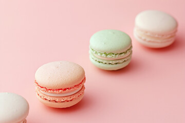 Obraz premium A row of French sweet macaroons in pastel colors on pink backdrop