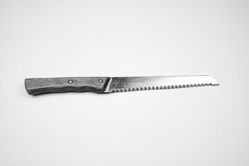 Knife with a wooden handle on an isolated background. The knife is serrated.