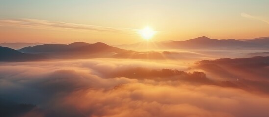 Fototapeta premium Stunning sunrise scenery of foggy valley at mountain range in autumn.