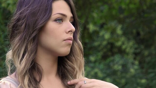 impatient young woman waiting for someone is touching her hair