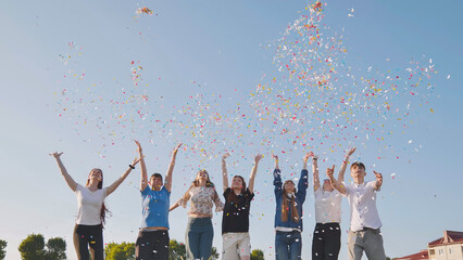 Friends toss colorful paper confetti from their hands.