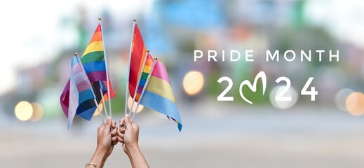 Happy Pride Month 2024 on rainbow flags raising background, concept for celebrations of LGBTQAI people in pride month, June, around the world.