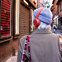 Vibrant urban chic: stylish gen z trendsetter in checkered coat and red headphones, embodying...