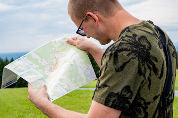 Man with touristic map in hands. Traveling Using Map. Man Holding Map In Hands. Looking For...
