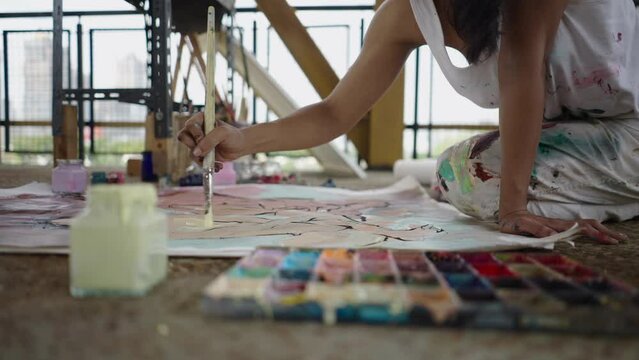 A womans hand paints a body on a canvas