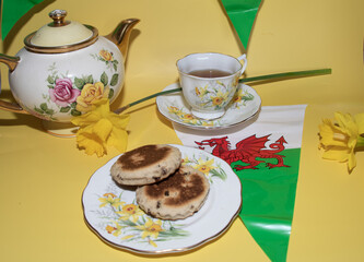 St davids  day  celebrations welsh  Flags  Welsh cake  Daffodils   Vintage  tea  party  and  teacup  on a yellow  back ground 