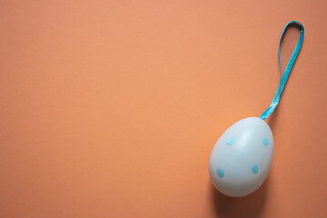 Easter egg on peach fuzz color background. Easter egg with copy space on beige background. Easter...