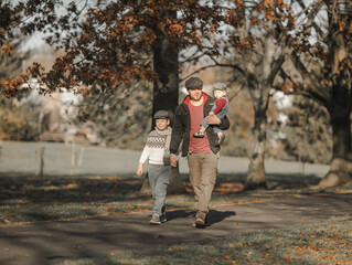 Fototapeta premium Fathers Day. Brothers and their dad enjoying time together in nature.Candid real family moment.