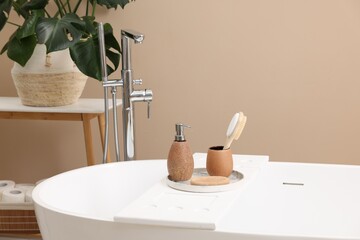 Different personal care products and accessories on bath tub in bathroom