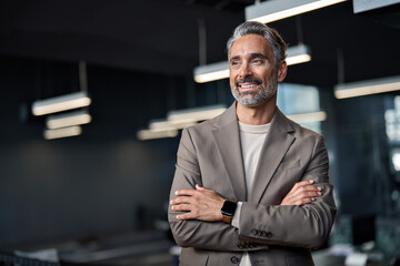 Happy confident mature 45 years old business man investor standing in office looking away. Middle aged rich business owner male ceo executive leader wearing suit at work thinking on future success. - obrazy, fototapety, plakaty