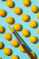 a paintbrush falling on top of yellow paint balls on a blue background