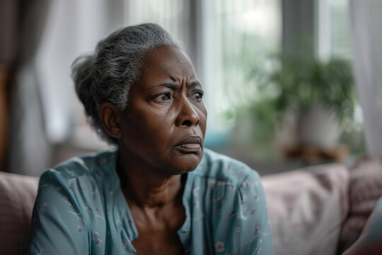 Depression, sad and senior African American woman at home with mourning and memory with mental health problem.
