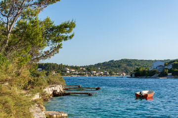 Small boat and wooden piers on coast of Vrnik island near Korcula, Croatia