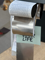 a roll of paper on top of a toilet paper dispenser, text on paper: run for your life