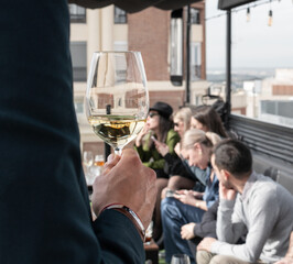 Close-up of a wine glass held by a man in a suit