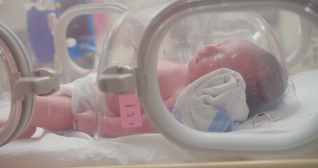 Closeup lovely little newborn baby infant lying in incubators for newborns, Newborn baby having the the breathing problem after birth, newborn in NICU, Neonatal intensive care unit