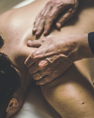 Soft focus view of man massaging a woman in a wellness center Oiled hands on a body relaxing the...