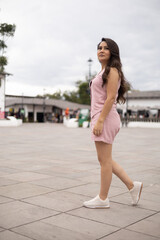walk in the city, young woman with long hair and wearing a pink dress, latin model beauty and fashion, lifestyle