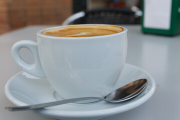 Primer plano de taza de café con leche en la terraza de un bar de Alicante, España