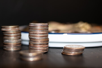 Towers of change sitting beside a white and blue plate.
