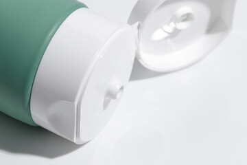 Open cosmetic tube on white background, closeup