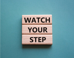 Watch your Step symbol. Concept words Watch your Step on wooden blocks. Beautiful grey green background. Business and Watch your Step concept. Copy space.