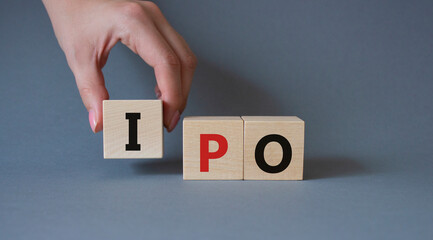 IPO- Initial Public Offering symbol. Concept word IPO on wooden cubes. Businessman hand. Beautiful grey background. Business and IPO concept. Copy space.